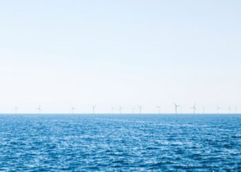 Parque eólico marino en el mar del Norte con aerogeneradores sobre el océano al atardecer.