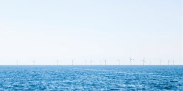 Parque eólico marino en el mar del Norte con aerogeneradores sobre el océano al atardecer.