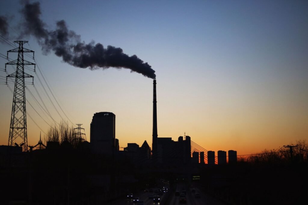 Central térmica de carbón en China emitiendo humo hacia el cielo, símbolo de la política energética fósil del país.