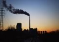 Central térmica de carbón en China emitiendo humo hacia el cielo, símbolo de la política energética fósil del país.