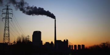 Central térmica de carbón en China emitiendo humo hacia el cielo, símbolo de la política energética fósil del país.