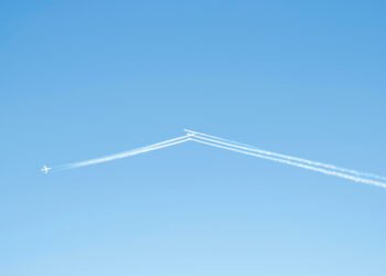 Estelas de condensación dejadas por aviones comerciales en el cielo a gran altitud