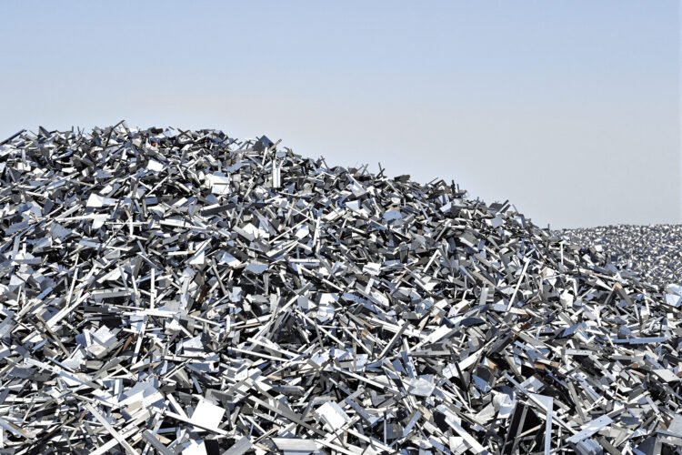 Chatarra de aluminio apilada en un centro de reciclaje industrial, materia prima del generador de energía de Voya Energy.