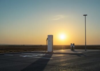 Estación de carga para vehículos eléctricos al atardecer, símbolo de la transición hacia movilidad de bajas emisiones.