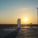 Estación de carga para vehículos eléctricos al atardecer, símbolo de la transición hacia movilidad de bajas emisiones.