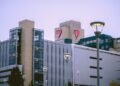 Fachada acristalada de un hospital moderno con luz solar reflejándose en las ventanas.