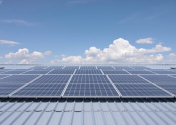 Paneles solares instalados en tejados residenciales bajo cielo nublado en Reino Unido.
