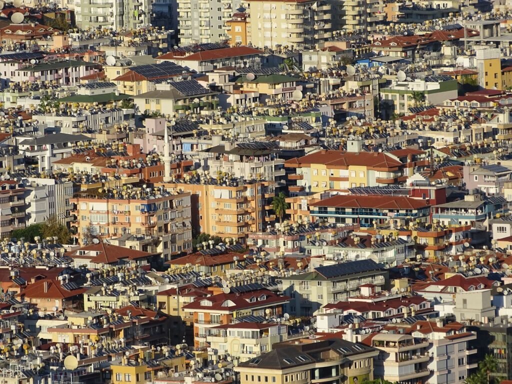 Paneles solares en techos de barrio urbano denso, representando la expansión solar descontrolada en países en desarrollo.
