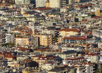 Paneles solares en techos de barrio urbano denso, representando la expansión solar descontrolada en países en desarrollo.
