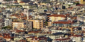 Paneles solares en techos de barrio urbano denso, representando la expansión solar descontrolada en países en desarrollo.