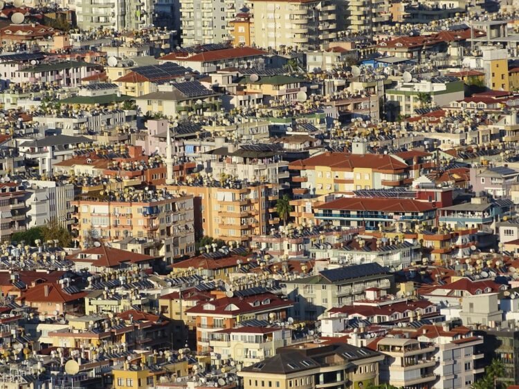 Paneles solares en techos de barrio urbano denso, representando la expansión solar descontrolada en países en desarrollo.
