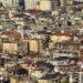 Paneles solares en techos de barrio urbano denso, representando la expansión solar descontrolada en países en desarrollo.