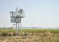 Estación meteorológica comunitaria en paisaje rural latinoamericano donde comunidades generan datos climáticos locales.