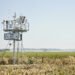 Estación meteorológica comunitaria en paisaje rural latinoamericano donde comunidades generan datos climáticos locales.