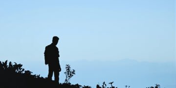 Silueta de defensor ambiental en bosque tropical colombiano, región de Cauca.