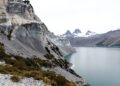 Vista de un desprendimiento de ladera en cerro patagónico junto a un lago, con vegetación arrastrada hacia el agua.