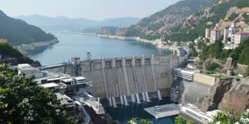 Represa hidroeléctrica en zona montañosa con río en Nepal, representando infraestructura energética vulnerable a inundaciones