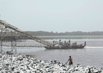 Draga minera ilegal operando en un río de la Amazonía peruana, extrayendo oro de los sedimentos.