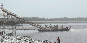 Draga minera ilegal operando en un río de la Amazonía peruana, extrayendo oro de los sedimentos.