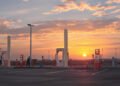 Estación de carga para vehículos eléctricos en China al atardecer, símbolo de la transición energética que impulsa la caída d