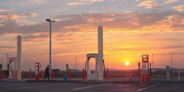 Estación de carga para vehículos eléctricos en China al atardecer, símbolo de la transición energética que impulsa la caída d