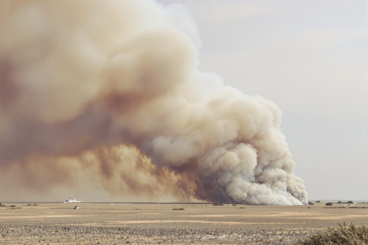 Humo denso elevándose de incendios forestales en paisaje tropical, como los que afectan las turberas de Indonesia.