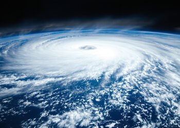 Vista satelital de un huracán aproximándose a islas en el océano Pacífico, con aguas cálidas alimentando la tormenta.