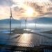 Parque de paneles solares y turbinas eólicas al atardecer, símbolo de la integración de IA china para eficiencia de renovable