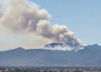 Humo de incendio forestal en zona montañosa de Córdoba, Argentina, con vegetación de pastizal.