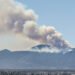 Humo de incendio forestal en zona montañosa de Córdoba, Argentina, con vegetación de pastizal.
