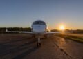 Silueta de un jet privado en la pista de aterrizaje al atardecer, símbolo de las emisiones desproporcionadas de la aviación p