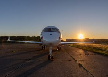 Silueta de un jet privado en la pista de aterrizaje al atardecer, símbolo de las emisiones desproporcionadas de la aviación p
