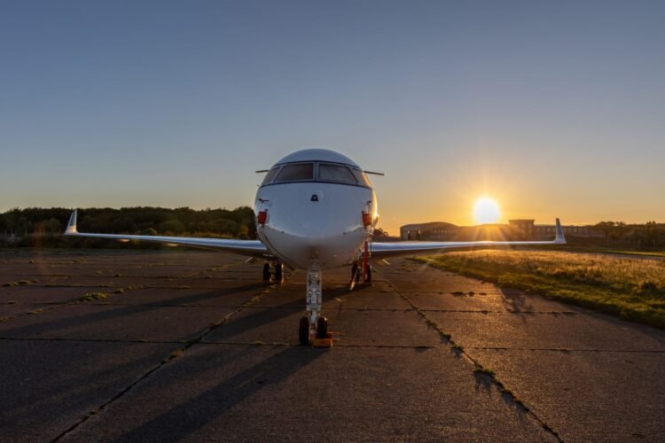 Silueta de un jet privado en la pista de aterrizaje al atardecer, símbolo de las emisiones desproporcionadas de la aviación p