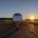 Silueta de un jet privado en la pista de aterrizaje al atardecer, símbolo de las emisiones desproporcionadas de la aviación p