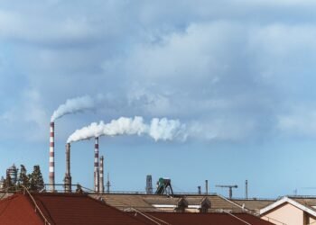 Chimeneas industriales emitiendo humo en una planta química, representando la contaminación del aire regulada por las nuevas