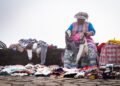 Mujer indígena en trabajo agrícola tradicional en terreno montañoso, representando las lideresas indígenas frente al cambio c