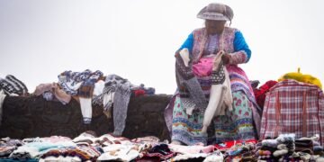 Mujer indígena en trabajo agrícola tradicional en terreno montañoso, representando las lideresas indígenas frente al cambio c