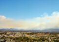 Paisaje post incendio forestal en Hawái con humo residual y vegetación quemada, similar al escenario de Maui tras los incendi