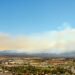 Paisaje post incendio forestal en Hawái con humo residual y vegetación quemada, similar al escenario de Maui tras los incendi