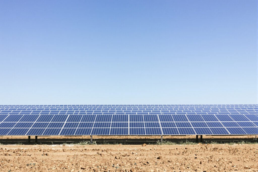 Campo de paneles solares fotovoltaicos bajo cielo despejado en Argentina.