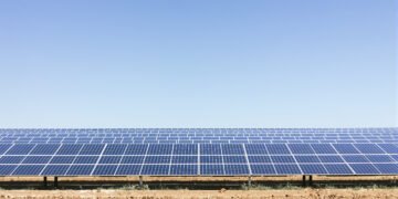 Campo de paneles solares fotovoltaicos bajo cielo despejado en Argentina.