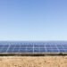 Campo de paneles solares fotovoltaicos bajo cielo despejado en Argentina.