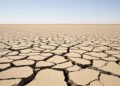 Tierra agrietada por sequía en campo español bajo cielo despejado, evidencia del récord térmico de septiembre 2026.