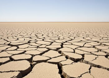 Tierra agrietada por sequía en campo español bajo cielo despejado, evidencia del récord térmico de septiembre 2026.