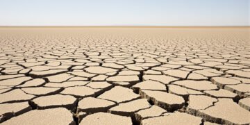 Tierra agrietada por sequía en campo español bajo cielo despejado, evidencia del récord térmico de septiembre 2026.