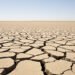 Tierra agrietada por sequía en campo español bajo cielo despejado, evidencia del récord térmico de septiembre 2026.