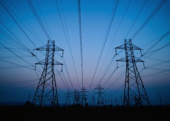 Líneas de transmisión eléctrica de alta tensión en China al atardecer, parte de la red que emite SF6.