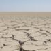 Tierra agrietada por sequía extrema, símbolo de los límites planetarios superados.