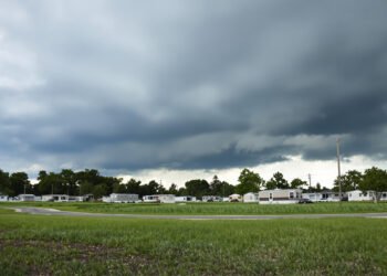 Parque de viviendas móviles en Florida bajo cielo de tormenta amenazante durante temporada de huracanes.