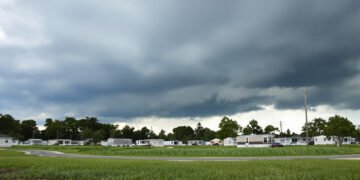 Parque de viviendas móviles en Florida bajo cielo de tormenta amenazante durante temporada de huracanes.